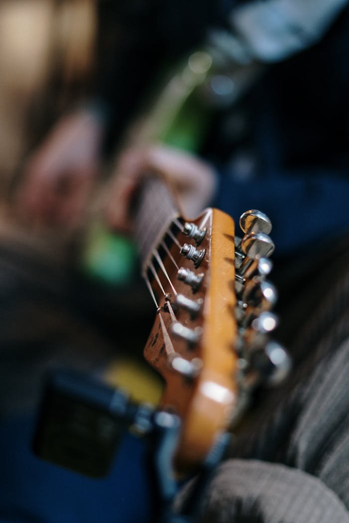 Artistic shot of an electric guitar headstock with blurred background, perfect for music themes.